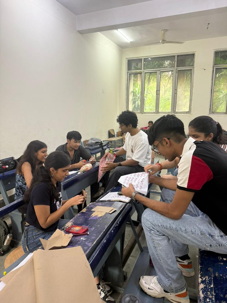 Members at desks cutting and assembling the case files for Who Killed The Company