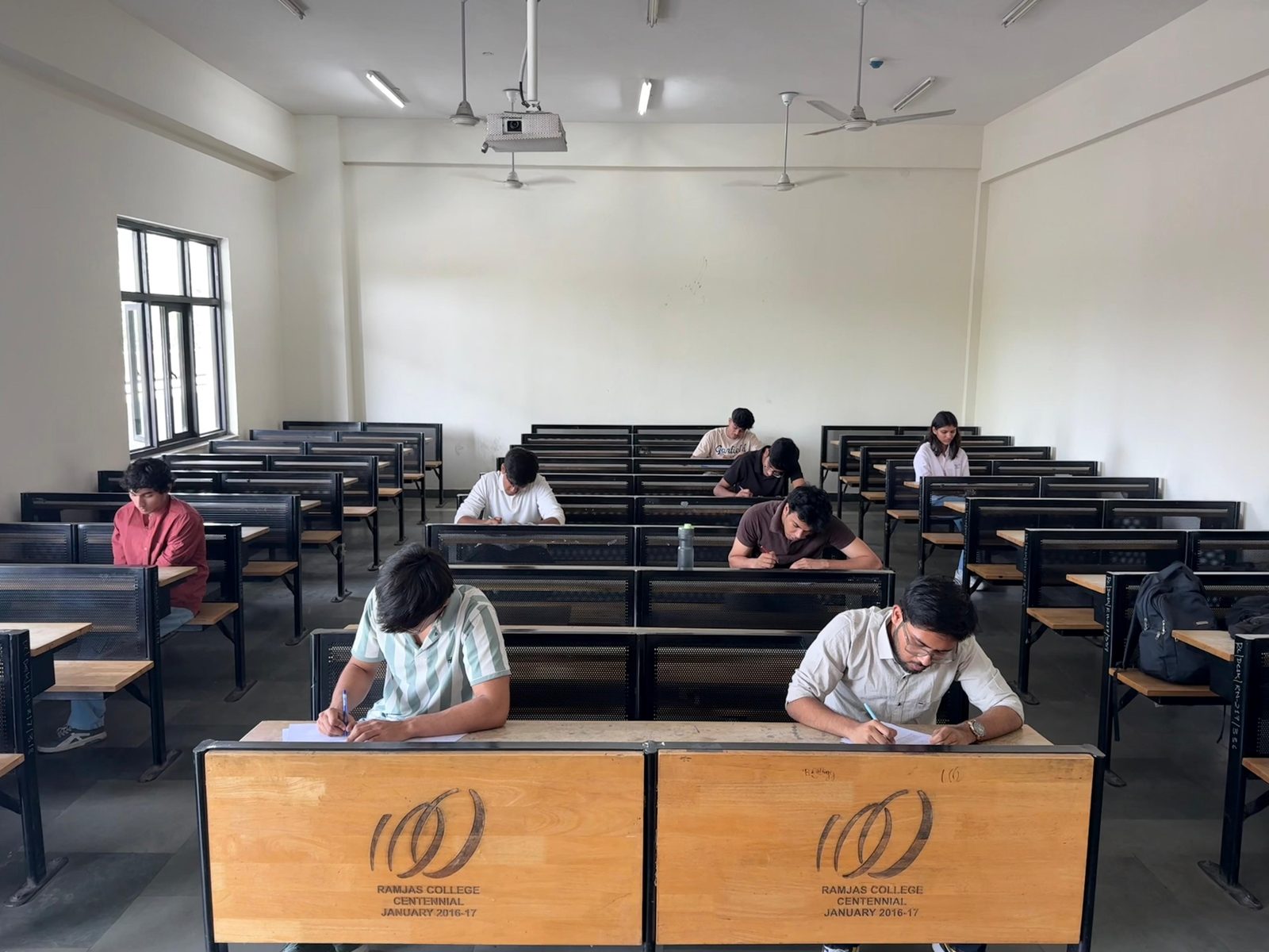 Students sitting a written round at desks in a Ramjas College classroom
